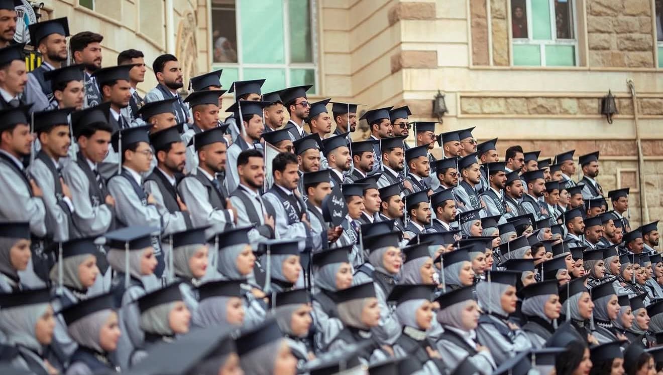 مدرّجات مليئة بالخرّيجين والخرّيجات يرتدون أوشحة تخرّج من لولو شوب في حفل تخرّج جامعي
